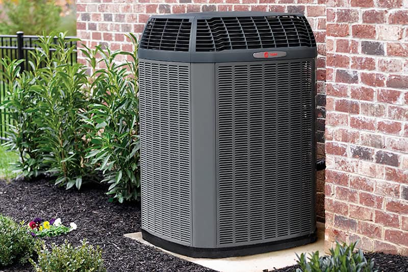 Air conditioning unit outside a brick home.