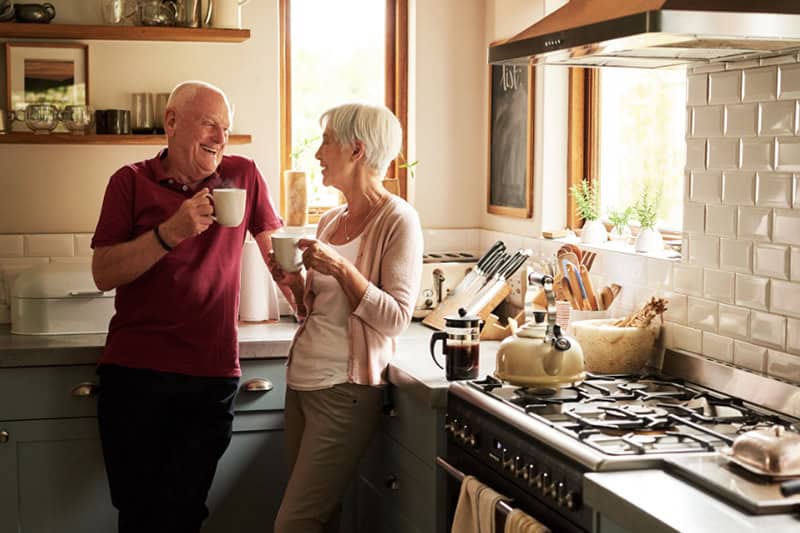 A senior couple spending quality time together at home drinking coffee.